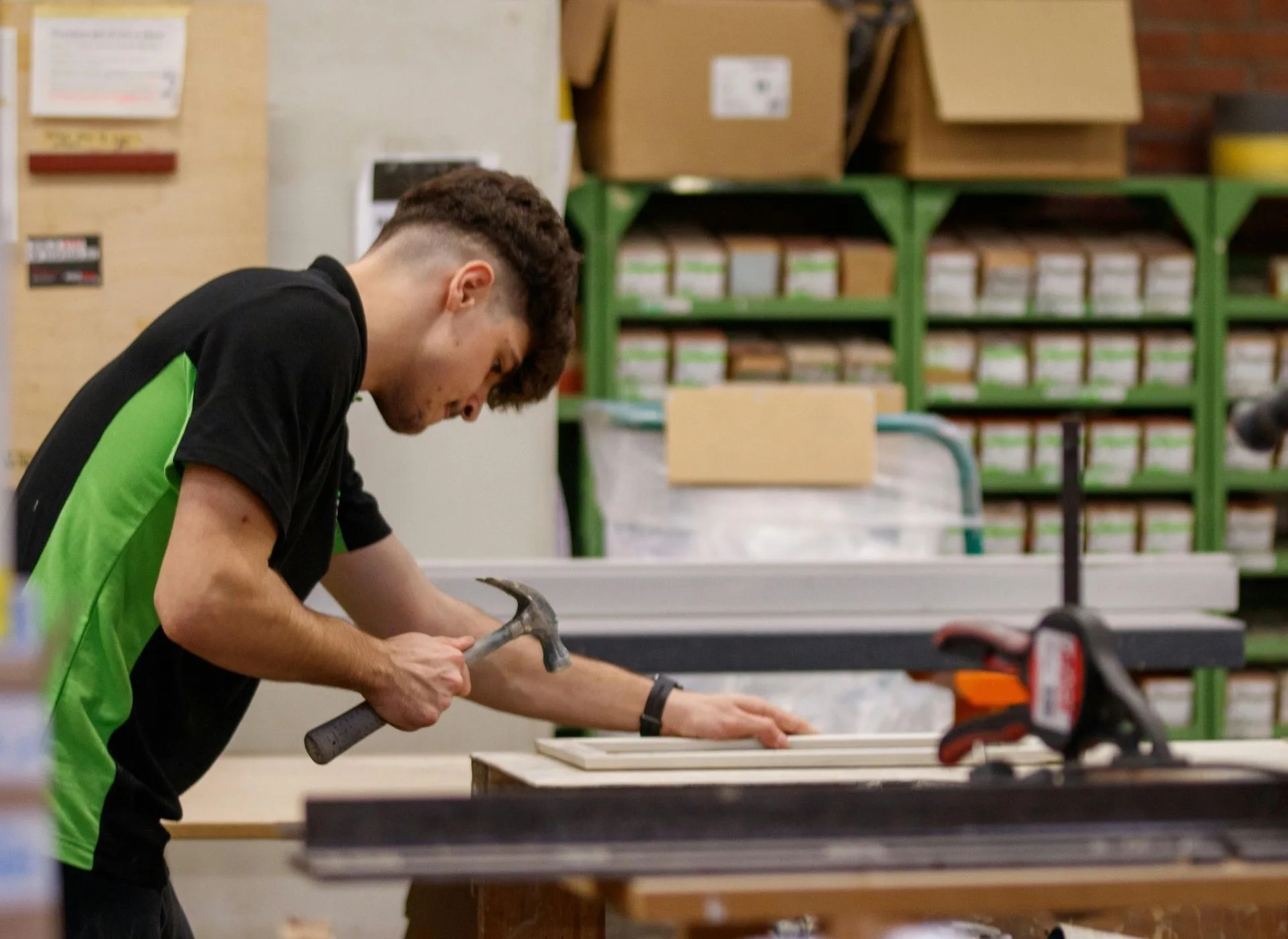 A young man with hammer in workshop