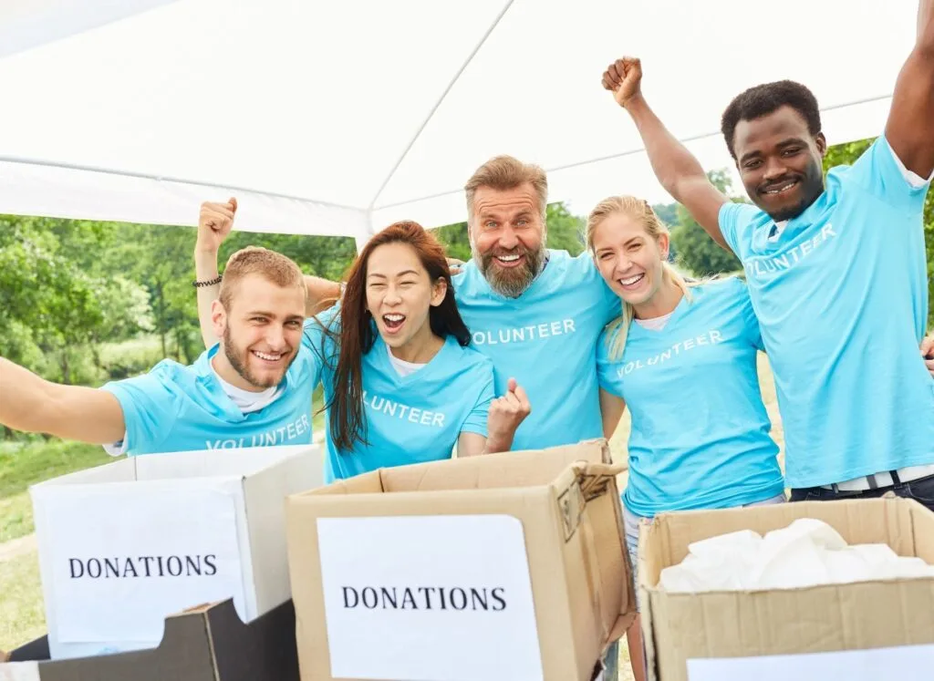 A group of fundraisers with light blue t-shirts on an donation boxes