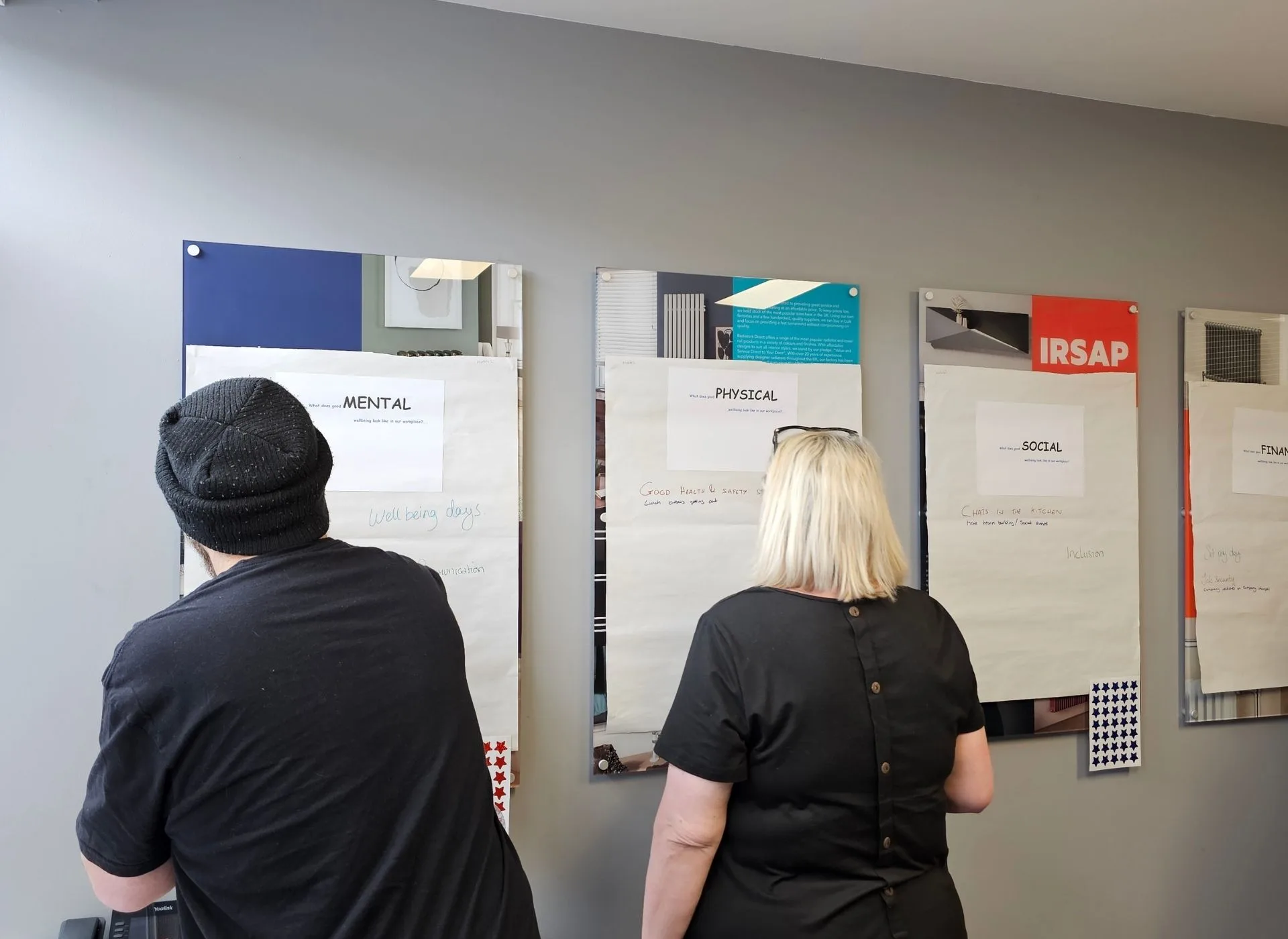 Two people stood writing on white boards