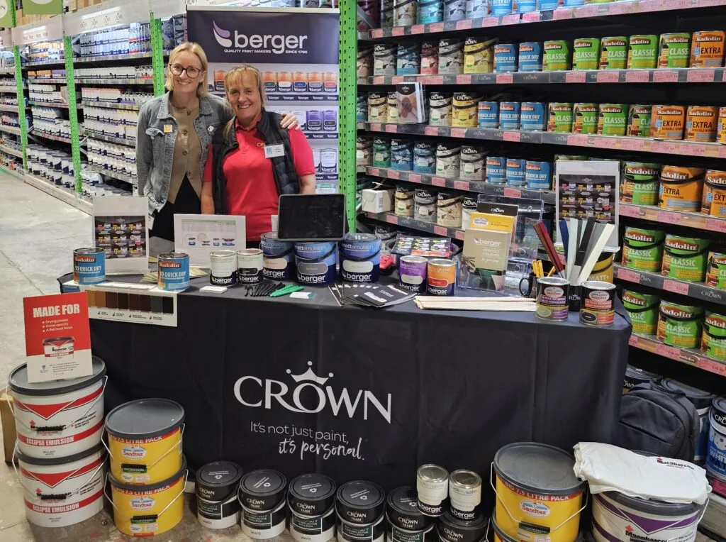 Anna Skeats with a Crown Paints representative at a paint display during a STAX brand event.
